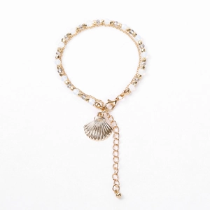 Détail d'un bracelet doré à plusieurs rangs avec pendentif coquillage et fermoir