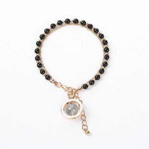 Handmade beaded bracelet with black onyx-style beads and gold ring pendant on white background