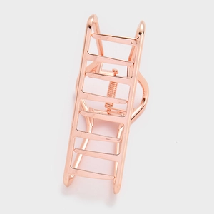 Détail de la pince à cheveux géométrique en métal or rose avec un design en échelle ajouré