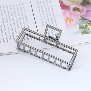 Close-up of a matte gunmetal rectangular hollow hair claw clip on a lifestyle background