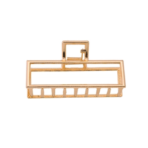 Macro view of gold rectangular hollow metal hair claw clip with frosted finish details