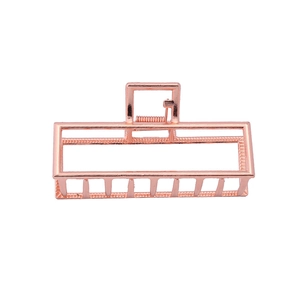 Close-up of a rectangular rose gold metal hair claw clip with a hollow frame and shiny finish