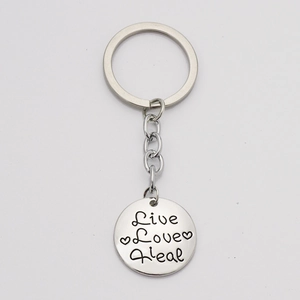 Polished silver stainless steel keychain with Live Love Heal engraved round pendant