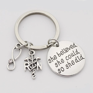 Detail of RN caduceus charm and engraved motivational phrase on silver nurse keychain