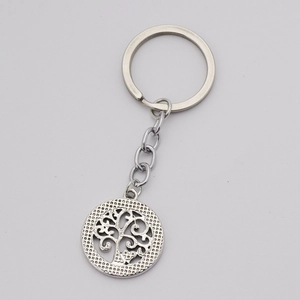Detail of silver hollow life tree metal pendant with delicate engraving and keyring