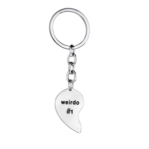 Macro shot of silver metal half-heart keychain with black weirdo #1 engraved text