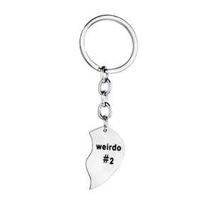 Detail of silver heart-shaped keychain engraved with weirdo #2 for best friends