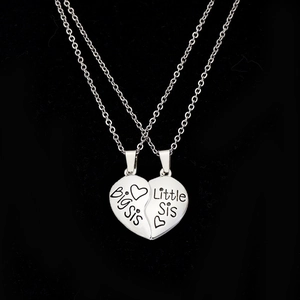 Dettaglio dei ciondoli a cuore Big Sis e Little Sis in finitura argento lucido