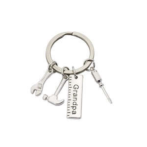 Close-up of silver metal tool keychain with hammer, wrench and Grandpa engraved ruler