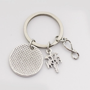 Detailed macro view of vintage silver alloy keychain with infinity and medical pendants