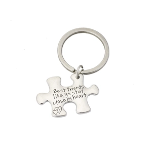 Detailed view of silver puzzle piece keychain with Best friends like us stay close in heart text