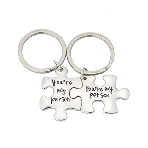 Polished silver puzzle piece keychains engraved with You're My Person for couples