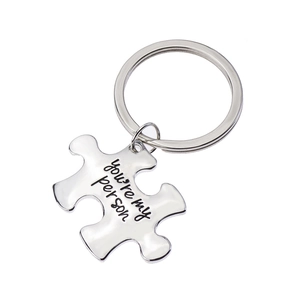 Detailed macro of silver puzzle keychain with 'You're my person' engraved text