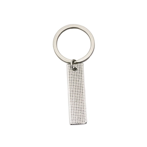 Porte-clés argenté minimaliste avec texture de grille industrielle sur fond blanc pur
