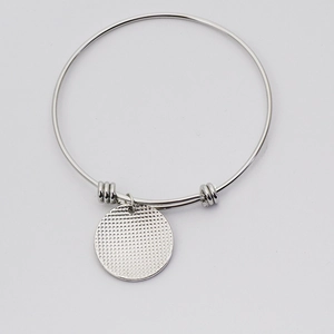 Minimalist adjustable silver wire bracelet with a textured grid round pendant