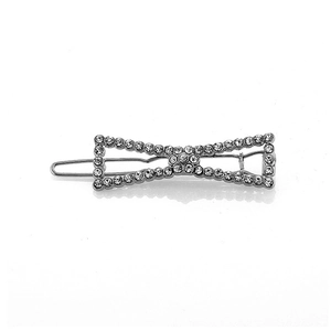 Close-up of bow-shaped silver metal hair clip with sparkling white rhinestones and crystals