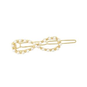 Detail view of infinity-shaped gold hair clip with glossy white pearls and metal clasp