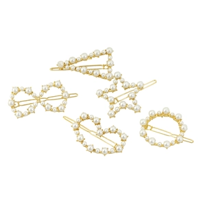 Détail d'un lot de cinq barrettes dorées avec perles blanches de formes variées