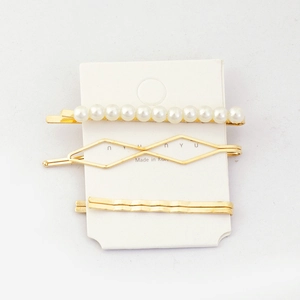 Three-piece golden hair clip set with artificial pearls and geometric wave designs