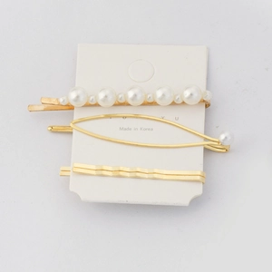 Three-piece golden hair clip set with artificial pearls and geometric wave designs