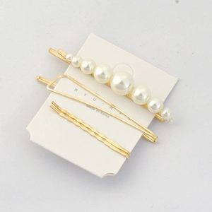 Close-up of elegant gold hair clip set with pearls and geometric wave designs