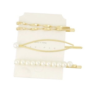 Detail of four-piece gold hair clip set with elegant pearls on a white display card
