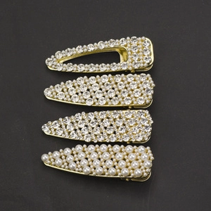 Détail de quatre barrettes à cheveux avec cristaux et perles sur alliage doré