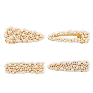Détail d'un lot de quatre barrettes dorées avec perles blanches et strass brillants