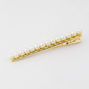 Barrette élégante en alliage doré avec rangée de perles sur fond blanc pur