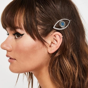 Retro rhinestone evil eye hair clip and silver hoop earring on a female model