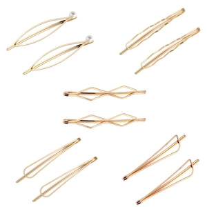 Detail view of gold geometric metal hair clips with pearls and minimalist line designs