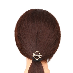 Golden alloy ponytail holder with pearl clover design on model with brown hair