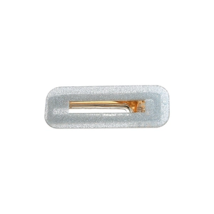 Détail d'une barrette rectangulaire pailletée argentée avec base en métal doré