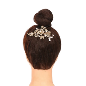 Elegant gold bridal hair comb with rhinestones and pearls on a high bun hairstyle