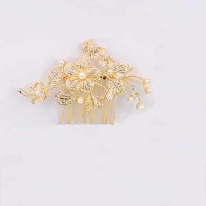 Detail of gold flower hair comb with white rhinestones and pearls for bridal hairstyles