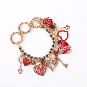 Elegant gold-tone multi-charm bracelet with red enamel hearts and sparkling crystals
