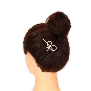 Elegant gold bow hair clip with crystal rhinestones on brown hair model for styling