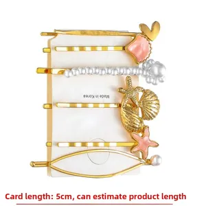 Detail view of 6-piece starfish and shell hair clip set on white card packaging