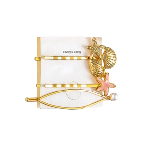 Three-piece gold starfish and seashell hair clip set with pink enamel and pearl accents