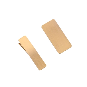 Detailed close-up of large matte gold geometric metal hair clips with brushed texture finish