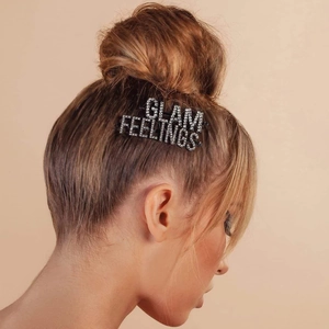 Close-up of GLAM and FEELINGS rhinestone hair clips set against light brown hair