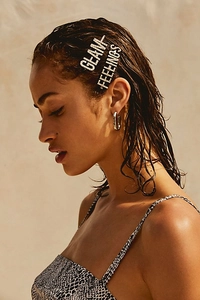Fashion model wearing GLAM and FEELINGS rhinestone letter hair pins and silver hoop earrings