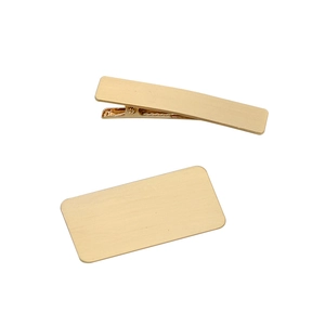 Detail of DIY golden hair clip components with brushed metal finish and duckbill base