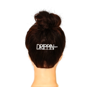 Silver alloy hair clip featuring DRIPPIN rhinestone letters on dark brown hair