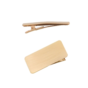 Detail view of large gold geometric metal hair clip showing side grip and brushed texture