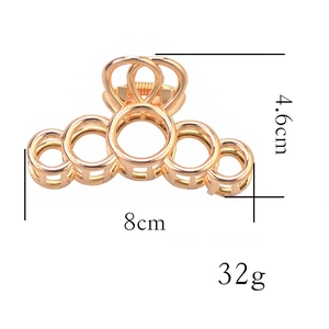 Vue détaillée d'une pince à cheveux géométrique dorée de 8cm au design circulaire