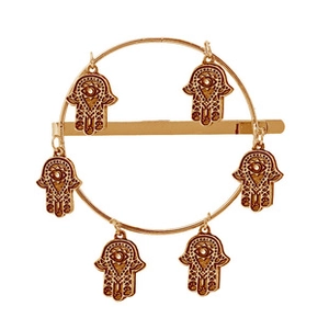 Détail d'une pince à cheveux circulaire dorée avec six pendentifs Main de Fatma suspendus