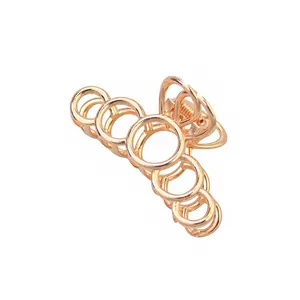 Détail d'une pince à cheveux en métal or rose poli avec des cercles ronds imbriqués