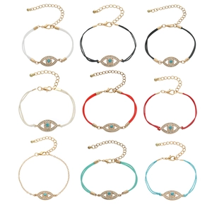 Macro view of assorted evil eye bracelets with gold plating and colorful cords