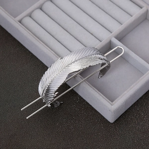 Retro silver feather hair stick in metal leaf design on a velvet jewelry tray